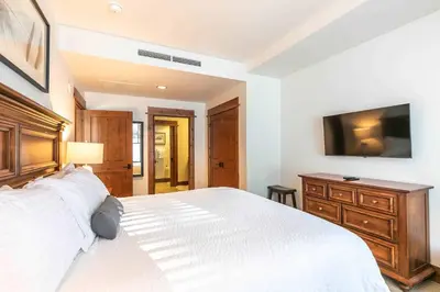 a bedroom with a large white bed and a television at Big Horn Lodge 410 by East West Hospitality in Truckee