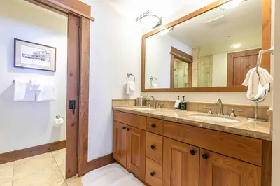 a bathroom with a sink and a large mirror at Big Horn Lodge 410 by East West Hospitality in Truckee