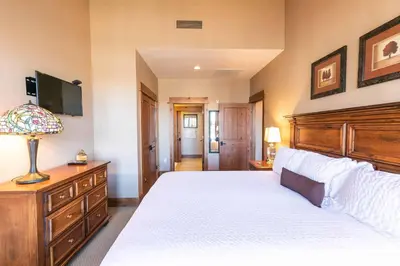 a bedroom with a large white bed and a television at Big Horn Lodge 511 by East West Hospitality in Truckee