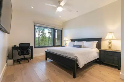 a bedroom with a bed and a desk and a window at Boulders 15136 by East West Hospitality in Truckee