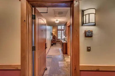 a hallway with a door leading into a room at Catamount Lodge 103 by East West Hospitality in Truckee