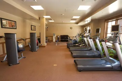 a gym with a row of treadmills and machines at Catamount Lodge 103B by East West Hospitality in Truckee