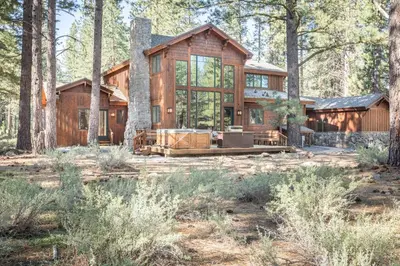 a large wooden house in the woods at Caleb Drive 12802 by East West Hospitality in Truckee