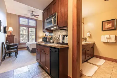 a kitchen with a sink and a microwave at Catamount Lodge 103A by East West Hospitality in Truckee
