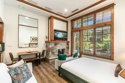 a bedroom with a bed and a fireplace at Catamount Lodge 105 by East West Hospitality in Truckee