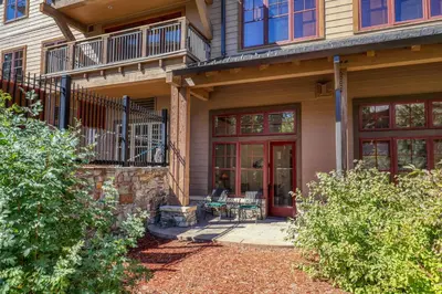 a house with a red door and a patio at Catamount Lodge 105 by East West Hospitality in Truckee