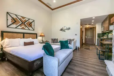 a bedroom with a bed and a couch at Catamount Lodge 105 by East West Hospitality in Truckee