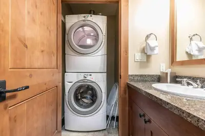 a washer and dryer in a bathroom with a sink at Catamount Lodge 201B by East West Hospitality in Truckee