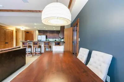 a kitchen with a long wooden table and chairs at Catamount Lodge 201B by East West Hospitality in Truckee