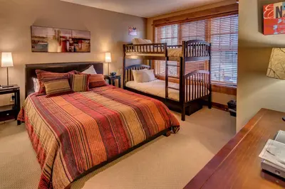 a bedroom with a bed and a bunk bed at Catamount Lodge 204 by East West Hospitality in Truckee