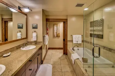 a bathroom with two sinks and a shower at Catamount Lodge 204 by East West Hospitality in Truckee
