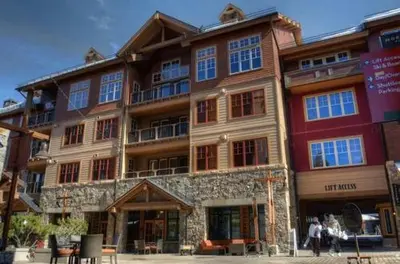 a large building with people walking in front of it at Catamount Lodge 201A by East West Hospitality in Truckee