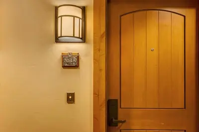 a wooden door with a sign next to it at Catamount Lodge 204A by East West Hospitality in Truckee