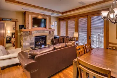 a living room with a couch and a fireplace at Catamount Lodge 204B by East West Hospitality in Truckee