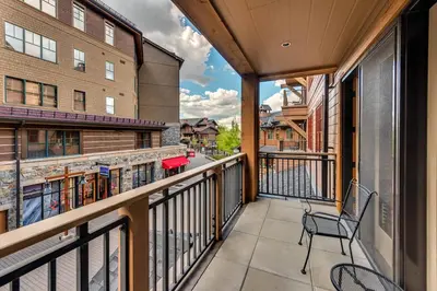 a balcony with a chair and a building at Catamount Lodge 206 by East West Hospitality in Truckee