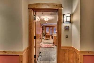 a hallway with a door leading to a dining room at Catamount Lodge 206 by East West Hospitality in Truckee
