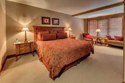 a bedroom with a large bed and a couch at Catamount Lodge 206 by East West Hospitality in Truckee