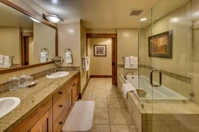 a bathroom with two sinks and a tub and a shower at Catamount Lodge 206 by East West Hospitality in Truckee
