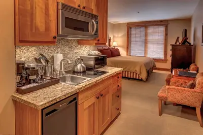 a kitchen with a sink and a bed in a room at Catamount Lodge 206A by East West Hospitality in Truckee