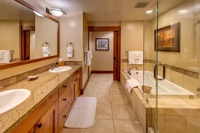 a bathroom with two sinks and a tub and a shower at Catamount Lodge 206B by East West Hospitality in Truckee