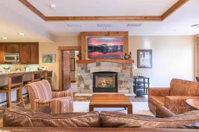 a living room with a couch and a fireplace at Catamount Lodge 308 by East West Hospitality in Truckee