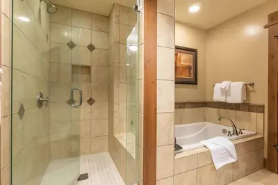 a bathroom with a shower and a bath tub at Catamount Lodge 308 by East West Hospitality in Truckee