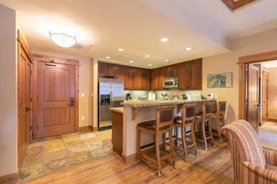a kitchen with a island with bar stools at Catamount Lodge 308 by East West Hospitality in Truckee