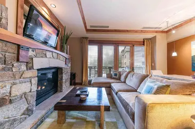 a living room with a couch and a fireplace at Catamount Lodge 305 by East West Hospitality in Truckee