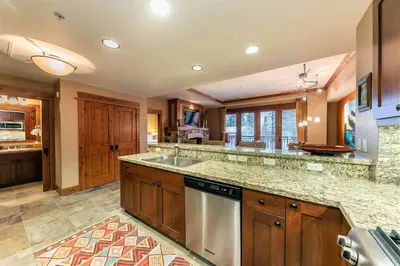a large kitchen with a sink and a dishwasher at Catamount Lodge 305 by East West Hospitality in Truckee