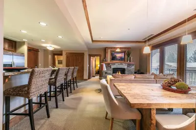 a kitchen and living room with a table and chairs at Catamount Lodge 305 by East West Hospitality in Truckee