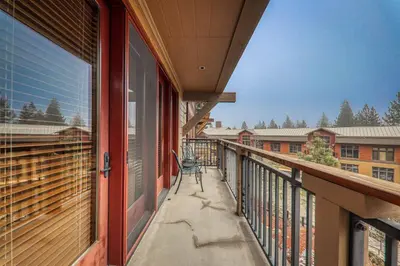 a balcony with a chair on the side of a building at Catamount Lodge 305B by East West Hospitality in Truckee