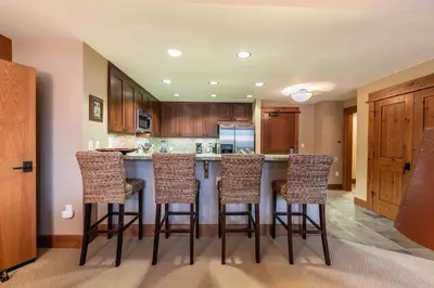 a kitchen with a island with bar stools at Catamount Lodge 305B by East West Hospitality in Truckee