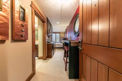 a hallway with a door leading to a kitchen at Catamount Lodge 305A by East West Hospitality in Truckee
