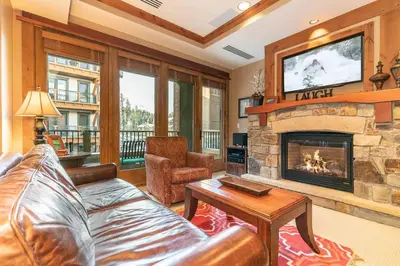 a living room with a couch and a fireplace at Catamount Lodge 312 by East West Hospitality in Truckee