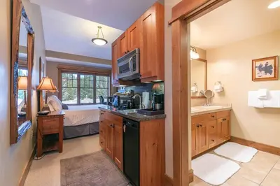 a kitchen with a sink and a microwave at Catamount Lodge 401 by East West Hospitality in Truckee