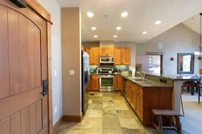 a kitchen with wooden cabinets and a stove top oven at Catamount Lodge 401 by East West Hospitality in Truckee
