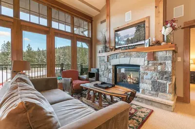 a living room with a couch and a fireplace at Catamount Lodge 401B by East West Hospitality in Truckee