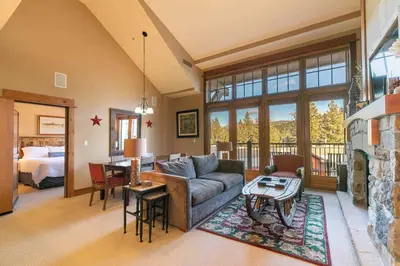 a living room with a couch and a table at Catamount Lodge 401B by East West Hospitality in Truckee