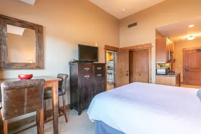a bedroom with a bed and a desk and a television at Catamount Lodge 401A by East West Hospitality in Truckee