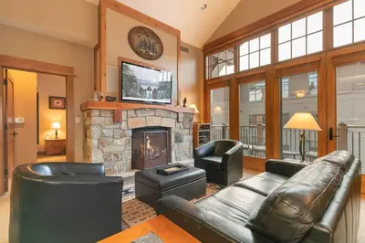 a living room with a couch and a fireplace at Catamount Lodge 404 by East West Hospitality in Truckee