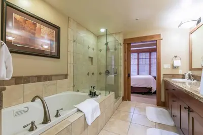 a bathroom with a tub and a shower and a sink at Catamount Lodge 404 by East West Hospitality in Truckee
