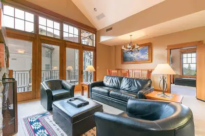 a living room with a leather couch and chairs at Catamount Lodge 404B by East West Hospitality in Truckee