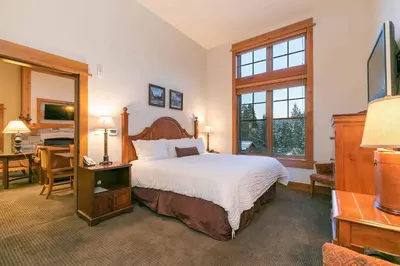 a bedroom with a large bed and a desk with a desk at Catamount Lodge 405 by East West Hospitality in Truckee