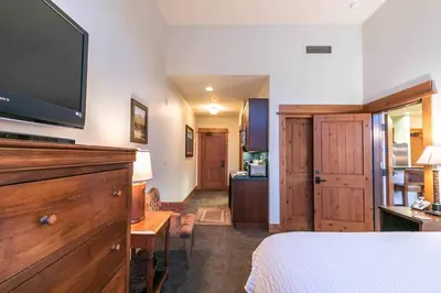 a bedroom with a bed and a flat screen tv at Catamount Lodge 405A by East West Hospitality in Truckee