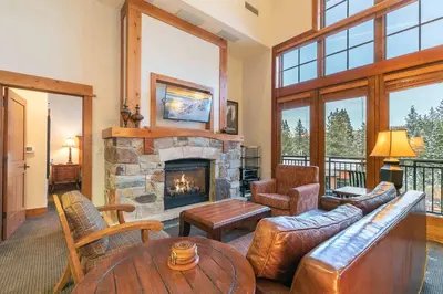 a living room with a fireplace and a couch at Catamount Lodge 405B by East West Hospitality in Truckee