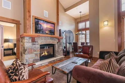 a living room with a fireplace and a couch at Catamount Lodge 408 by East West Hospitality in Truckee