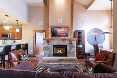 a living room with a fireplace and a couch at Catamount Lodge 408 by East West Hospitality in Truckee