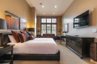 a bedroom with a bed and a flat screen tv at Catamount Lodge 408 by East West Hospitality in Truckee