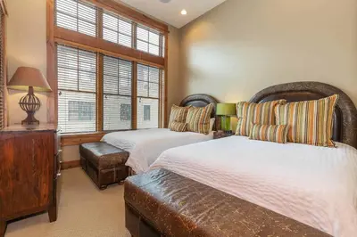 a bedroom with two beds and a window at Catamount Lodge 408 by East West Hospitality in Truckee