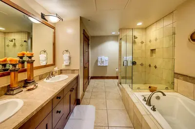 a bathroom with two sinks and a tub and a shower at Catamount Lodge 411 by East West Hospitality in Truckee